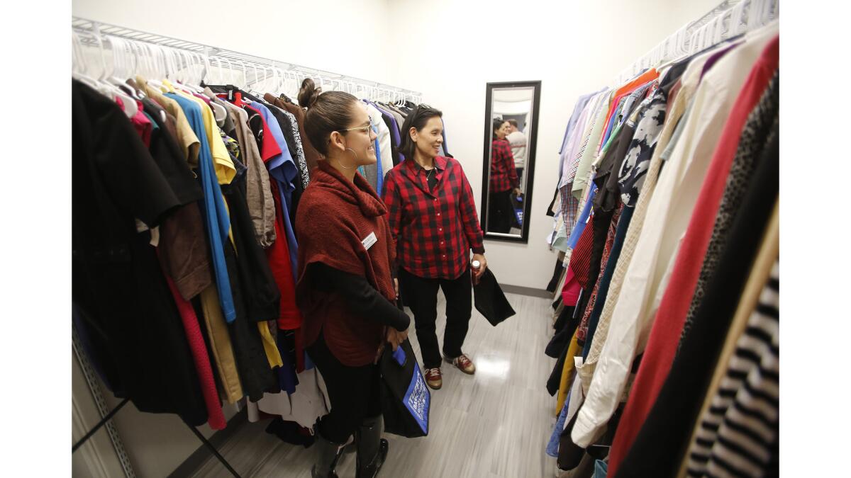 Guests stop to admire the coats and shirts in the Tuffy's Basic Needs Center career closet after the center's grand opening Wednesday at Cal State Fullerton.