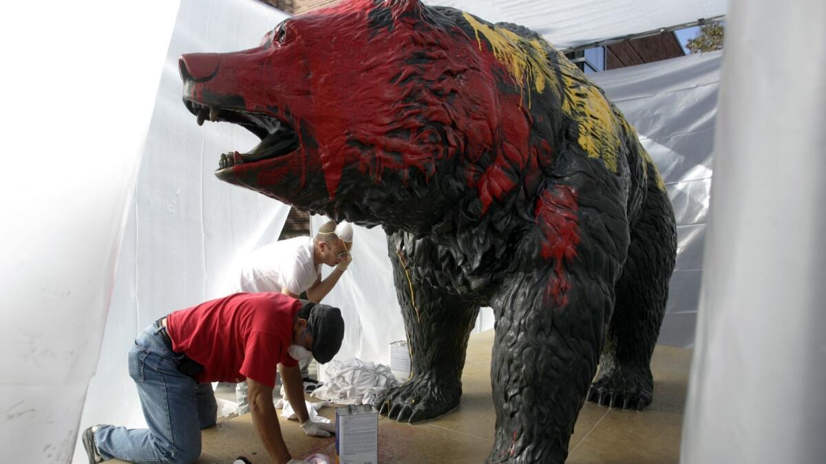 Workers clean off red and yellow paint from the Bruin Bear in 2009. In November, vandals again defaced the statue.