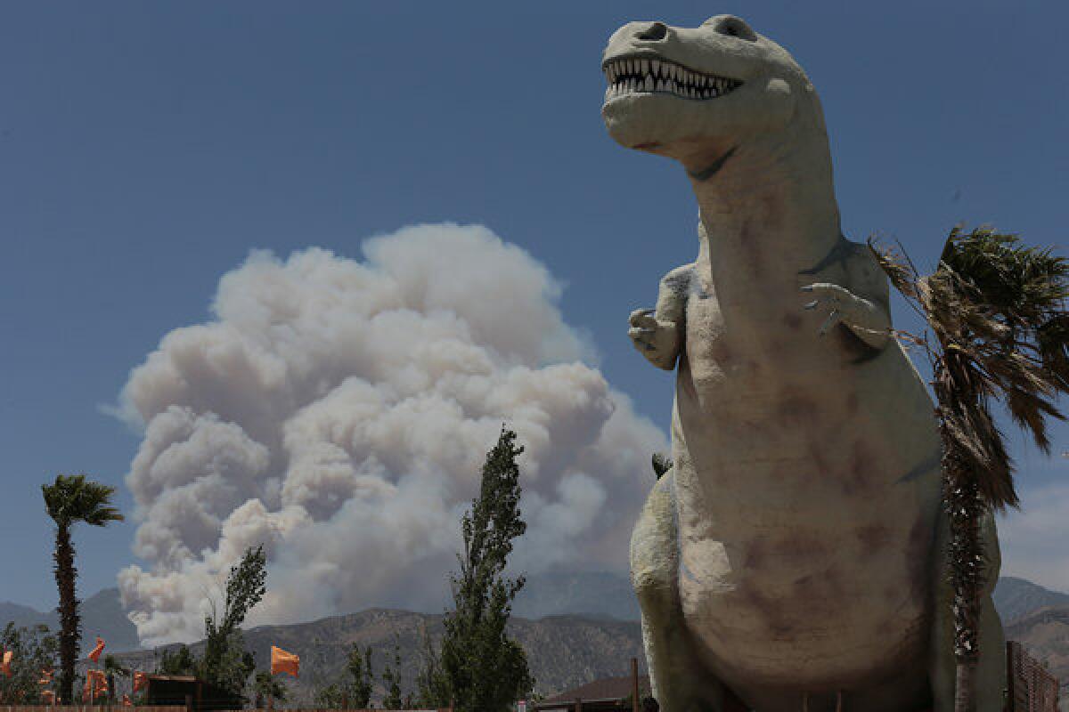 Smoke is seen Sunday from the Hathaway fire, a few miles from the World's Biggest Dinosaurs site in Cabazon, Calif.