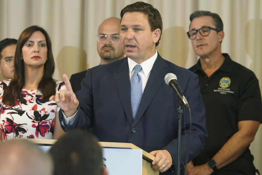 In this Aug. 10, 2021, photo, Florida Gov. Ron DeSantis answers questions related to school openings and the wearing of masks in Surfside, Fla. Top Republicans are battling school districts in their own states’ urban, heavily Democratic areas over whether students should be required to mask up as they head back to school. (AP Photo/Marta Lavandier)