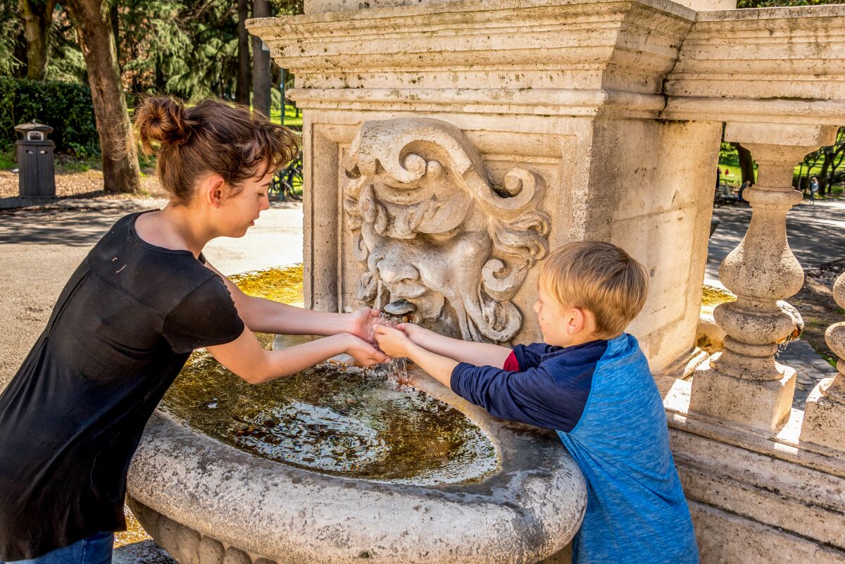 Kids cool themselves with water from one of several fountains in Villa Borghese, one of the largest green spaces in Rome. Villa Borghese is home to multiple art museums and attractions, including the Galleria Borghese, replica Globe Theater, zoo and children's museum.
