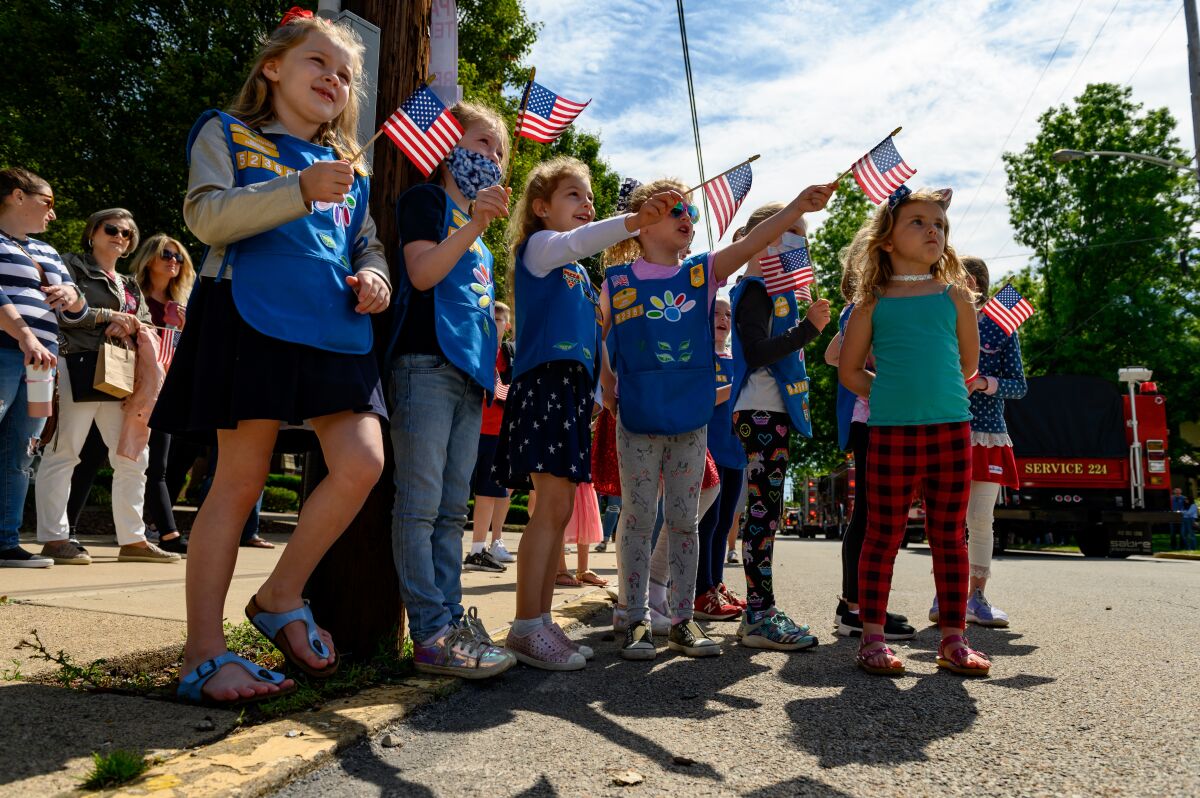 Girl Scouts in Troop 52368 wait for candy and watch parade marchers.