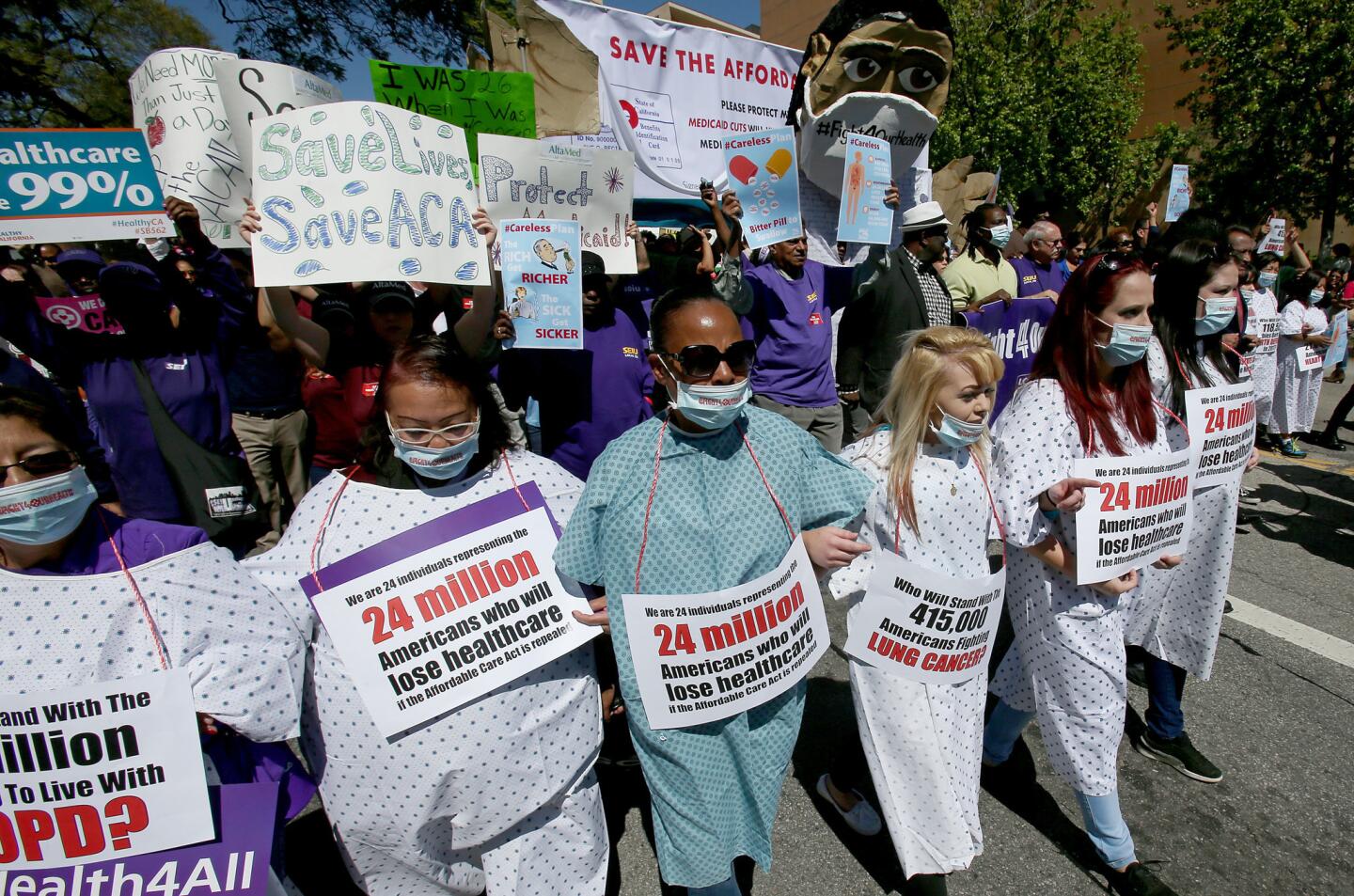 Healthcare workers and union members march down Temple Street in downtown Los Angeles on Thursday in support of the Affordable Care Act, also known as Obamacare.