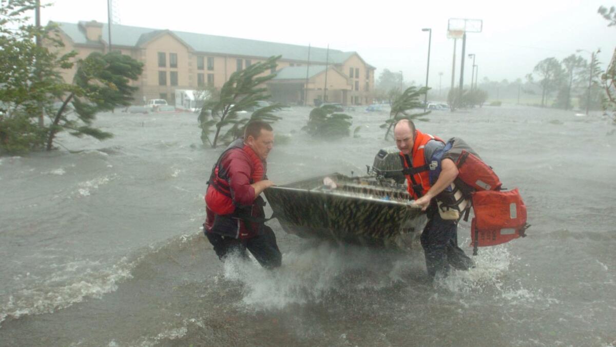 Fire and rescue personnel head out to save a family trapped by Hurricane Katrina in Pascagoula, Miss.