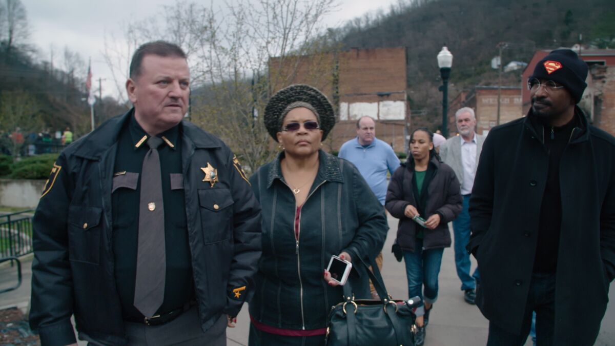 The white sheriff of Welch, W.Va., walks with a Black TV commentator and a leader of an L.A. substance-abuse services group.