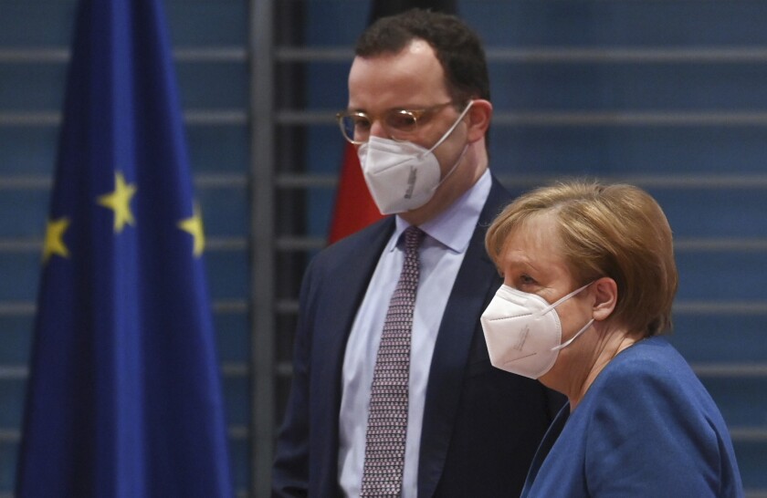 FILE - In this Jan. 6, 2021 file photo, German Chancellor Angela Merkel and Federal Health Minister Jens Spahn arrive at the weekly cabinet meeting wearing face masks in Berlin, Germany. The coronavirus pandemic is colliding with politics as Germany embarks on its vaccination drive and one of the most unpredictable election years in its post-World War II history. (John Macdougall/Pool via AP, File)