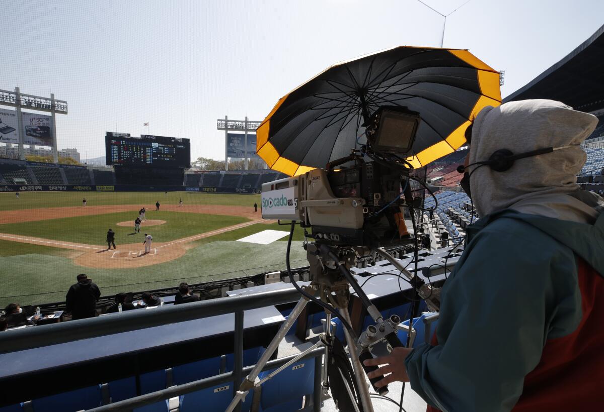 Un camarógrafo filma un juego de práctica de los LG Twins de la liga de béisbol de Corea del Sur, en Seúl, el domingo 5 de abril de 2020. (AP Foto/Lee Jin-man)