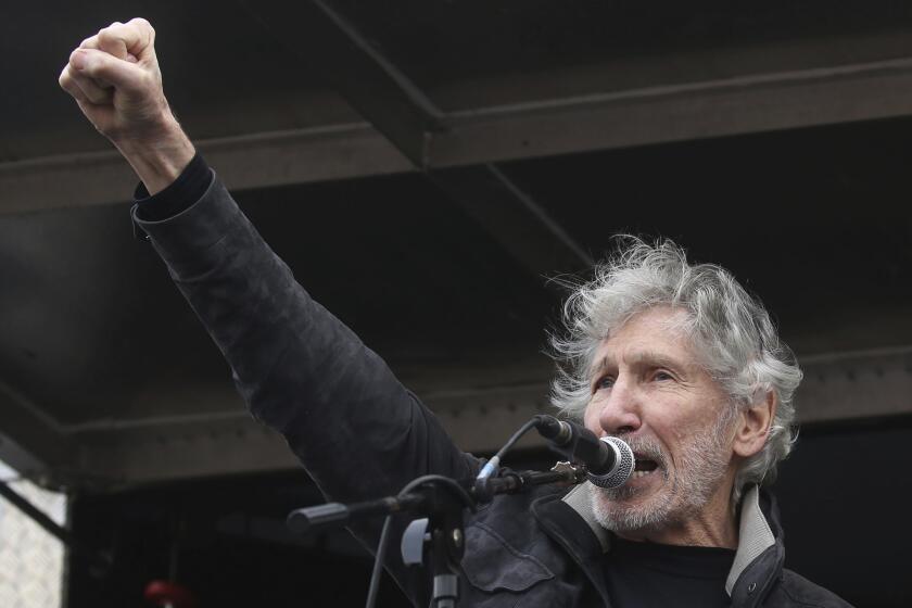 Former Pink Floyd bass player Roger Waters speaks to crowds gathered at Parliament Square in London, protesting against the imprisonment and extradition of Wikileaks founder Julian Assange extradition, Saturday Feb. 22, 2020. (Isabel Infantes/PA via AP)