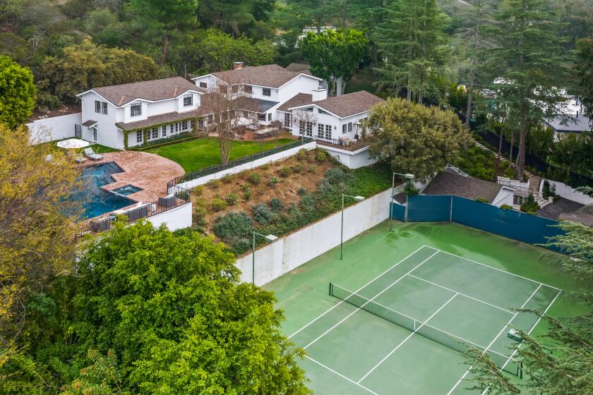 The 1.5-acre spread includes a swimming pool, tennis court and L-shaped home built in the 1970s.