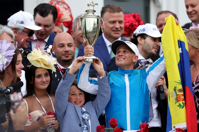 Jockey Javier Castellano celebrates in winners circle after ridding Mage to win the 149th running of the Kentucky Derby
