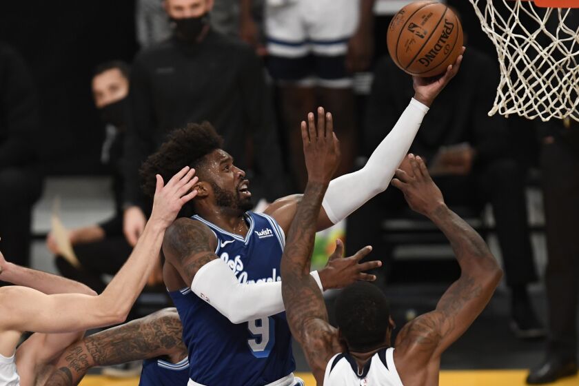 Los Angeles Lakers guard Wesley Matthews, center, goes up for a basket over Minnesota Timberwolves.