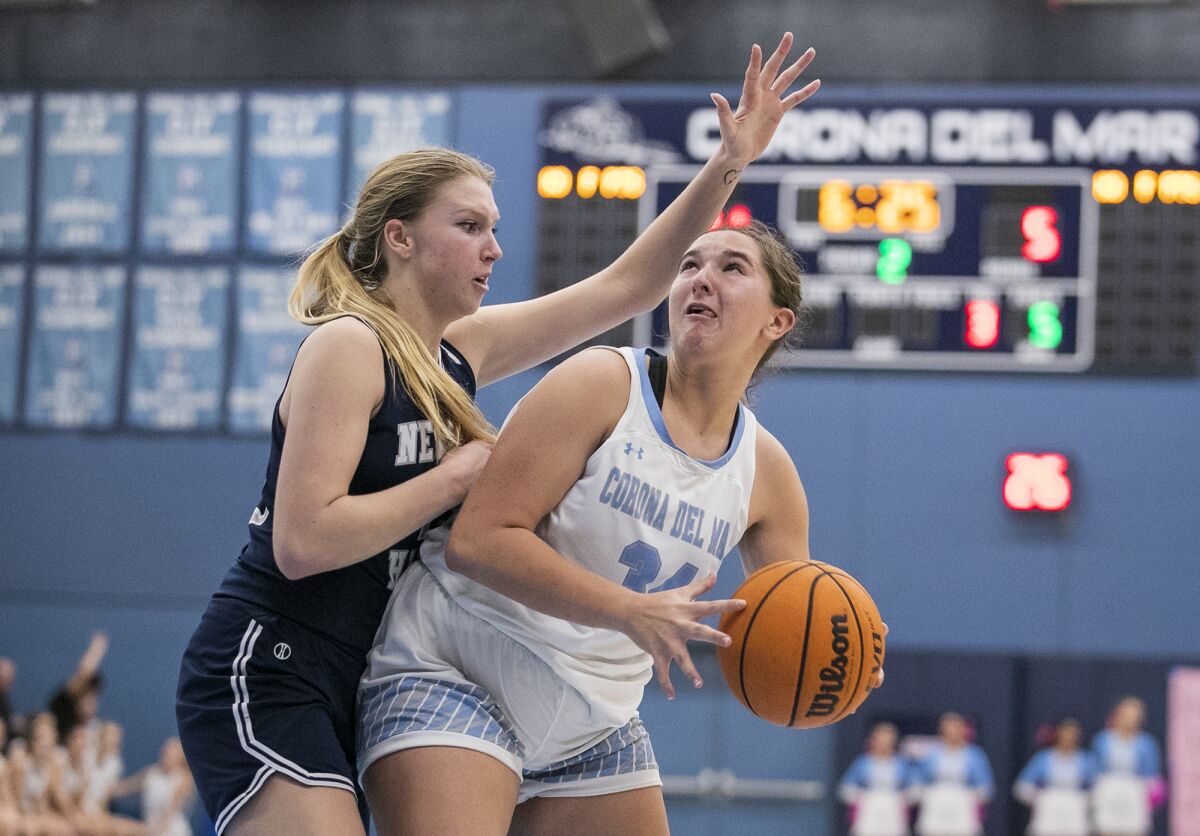 Corona del Mar's Kayly Honig goes up against Newport Harbor's Kaitlyn Leibe in the Battle of the Bay girls' basketball game.