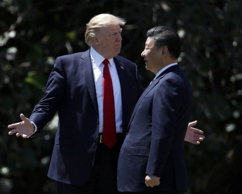 In this April 7, 2017, file photo, U.S. President Donald Trump gestures as he and Chinese President Xi Jinping walk together after their meetings at Mar-a-Lago in Palm Beach, Florida.
