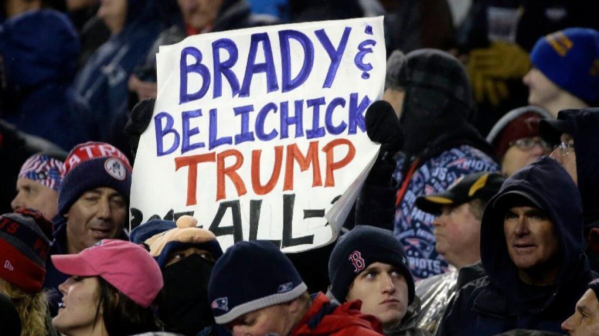 A New England Patriots fan holds a sign referring to Patriots quarterback Tom Brady, Coach Bill Belichick and President Donald Trump during the first half of the AFC championship on Jan. 22.