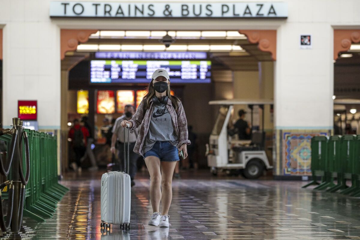 A masked traveler walks through the main lobby of Los Angeles' Union Station on July 12.