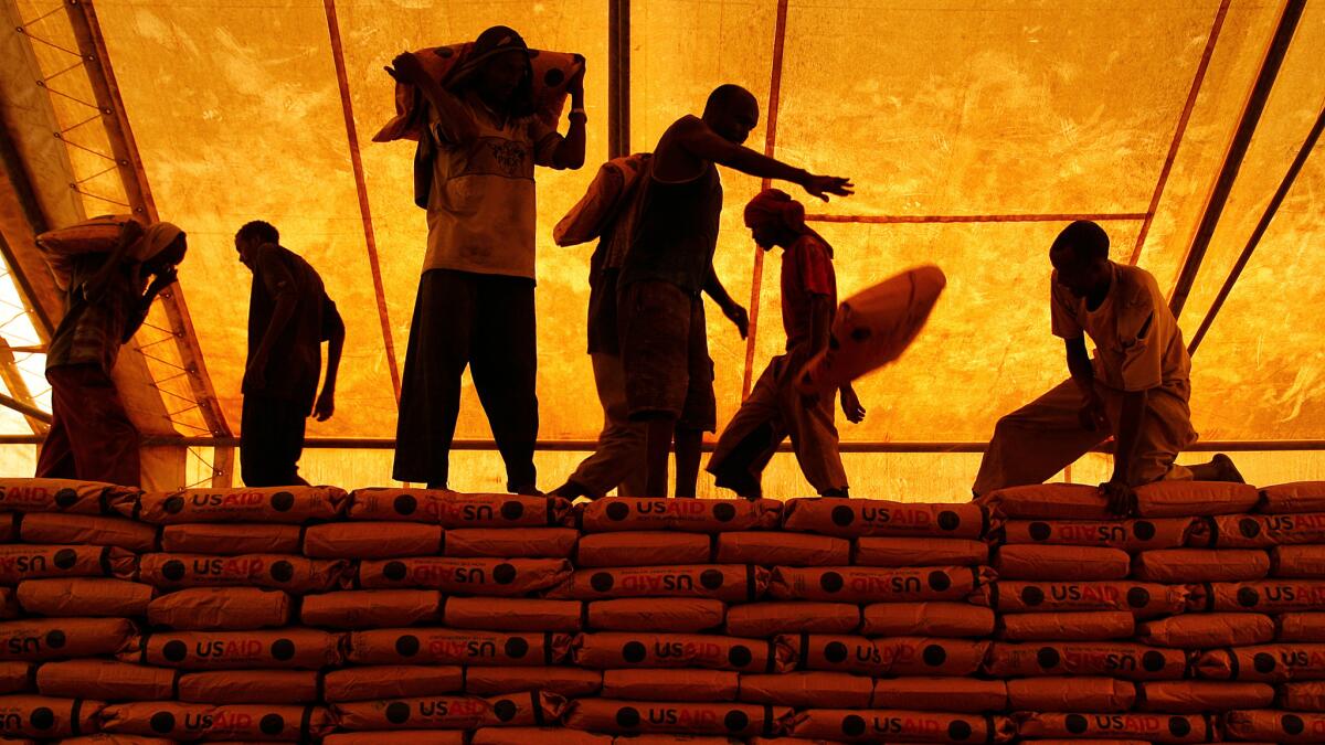 Workers at Dadaab refugee camp in Kenya's North Eastern Province in 2009 unload 55-pound bags of cornmeal provided by the United States Agency for International Development.