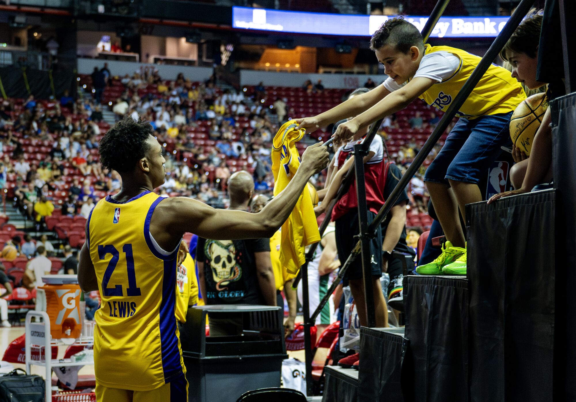 Maxwell Lewis signs an autograph for a young Lakers fan during an NBA Summer League game.