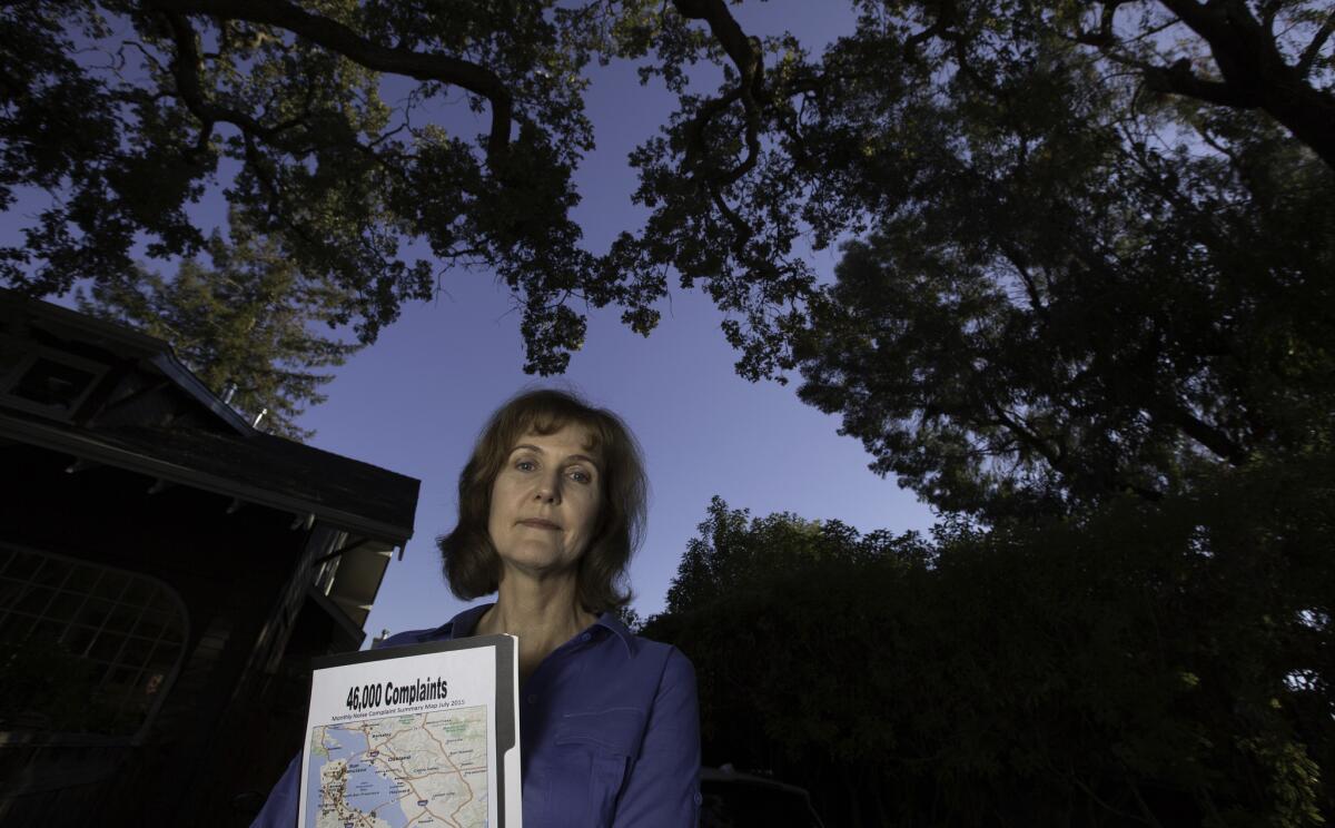 Rachel Kellerman with a graphic showing points where over 40,000 complaints to the FAA were logged in front of her home in Palo Alto, Calif.