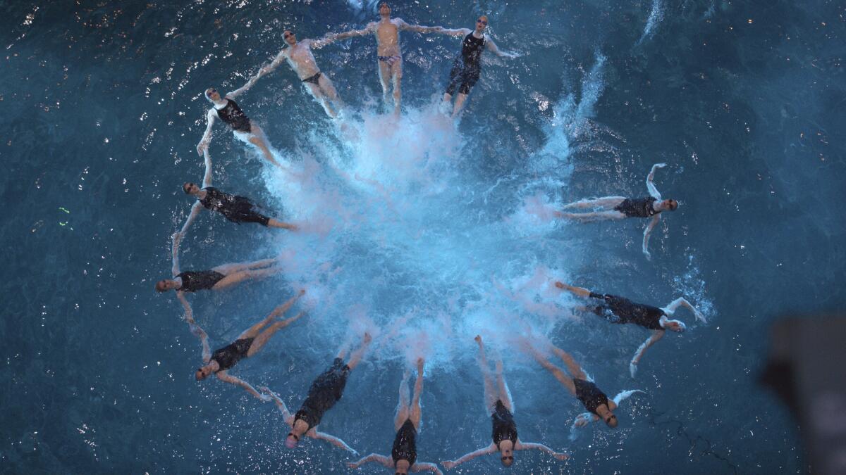 Synchronized swimmers form a circle in a pool.