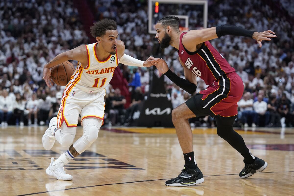 FILE - Atlanta Hawks guard Trae Young (11) loses control of the ball as he drives to the basket against Miami Heat forward Caleb Martin (16) during the second half of Game 5 of an NBA basketball first-round playoff series April 26, 2022, in Miami. The Hawks are heading into training camp looking for a bit of a reboot. First up: improving the communication between coach Nate McMillan and star guard Young. (AP Photo/Wilfredo Lee, File)