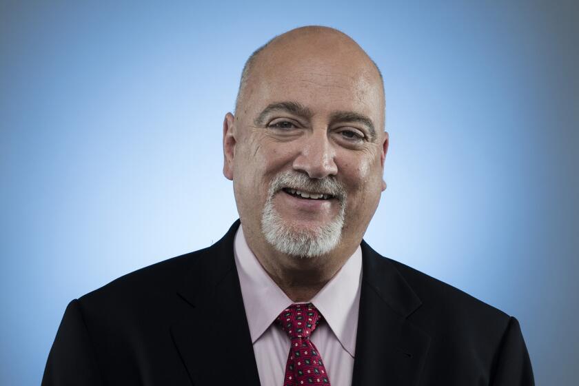 Los Angeles Times columnist Bill Plaschke poses in a suit for a staff portrait