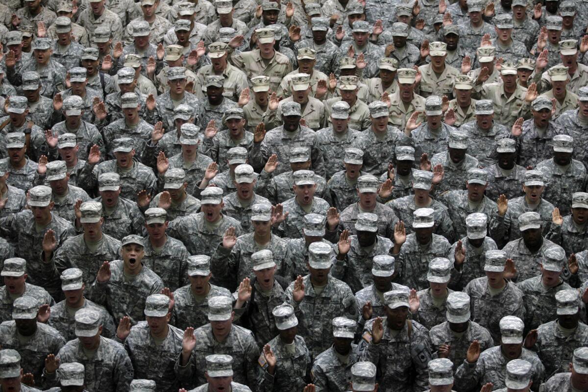 U.S. military service members take an oath at a mass reenlistment ceremony in Baghdad, Iraq, on July 4, 2008.