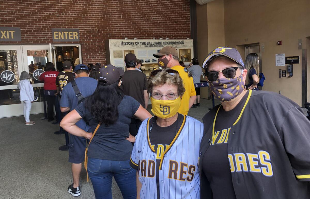 Mary Miller (right) and Barbara Whitman of San Diego wait to enter the Padres Team Store before season opener at Petco Park.