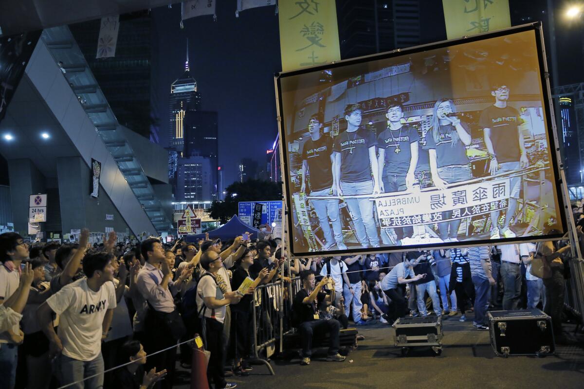 Pro-democracy protesters at an occupied area outside the government headquarters in Hong Kong's Admiralty district cheer Oct. 21 as they listen to student leaders after talks between Hong Kong government officials and the students.