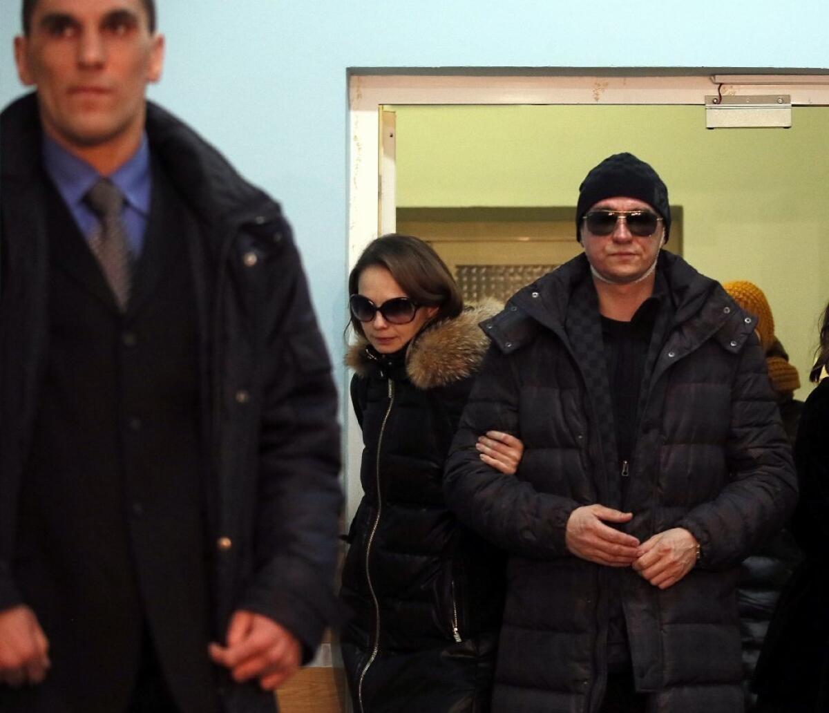 Sergei Filin, right, the artistic director of the Bolshoi Ballet, and his wife, Maria Provich, are seen as they leave a hospital in Moscow on Feb. 4.