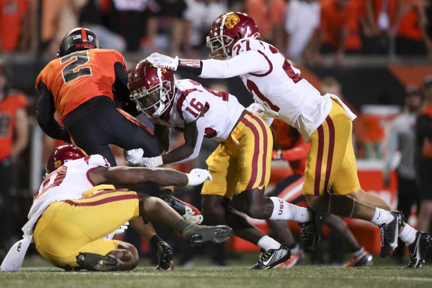 Oregon State wide receiver Anthony Gould is taken down by Southern California's Ralen Goforth, left, Prophet Brown, center, and Bryson Shaw during the second half of an NCAA college football game Saturday, Sept. 24, 2022, in Corvallis, Ore. Southern California won 17-14. (AP Photo/Amanda Loman)