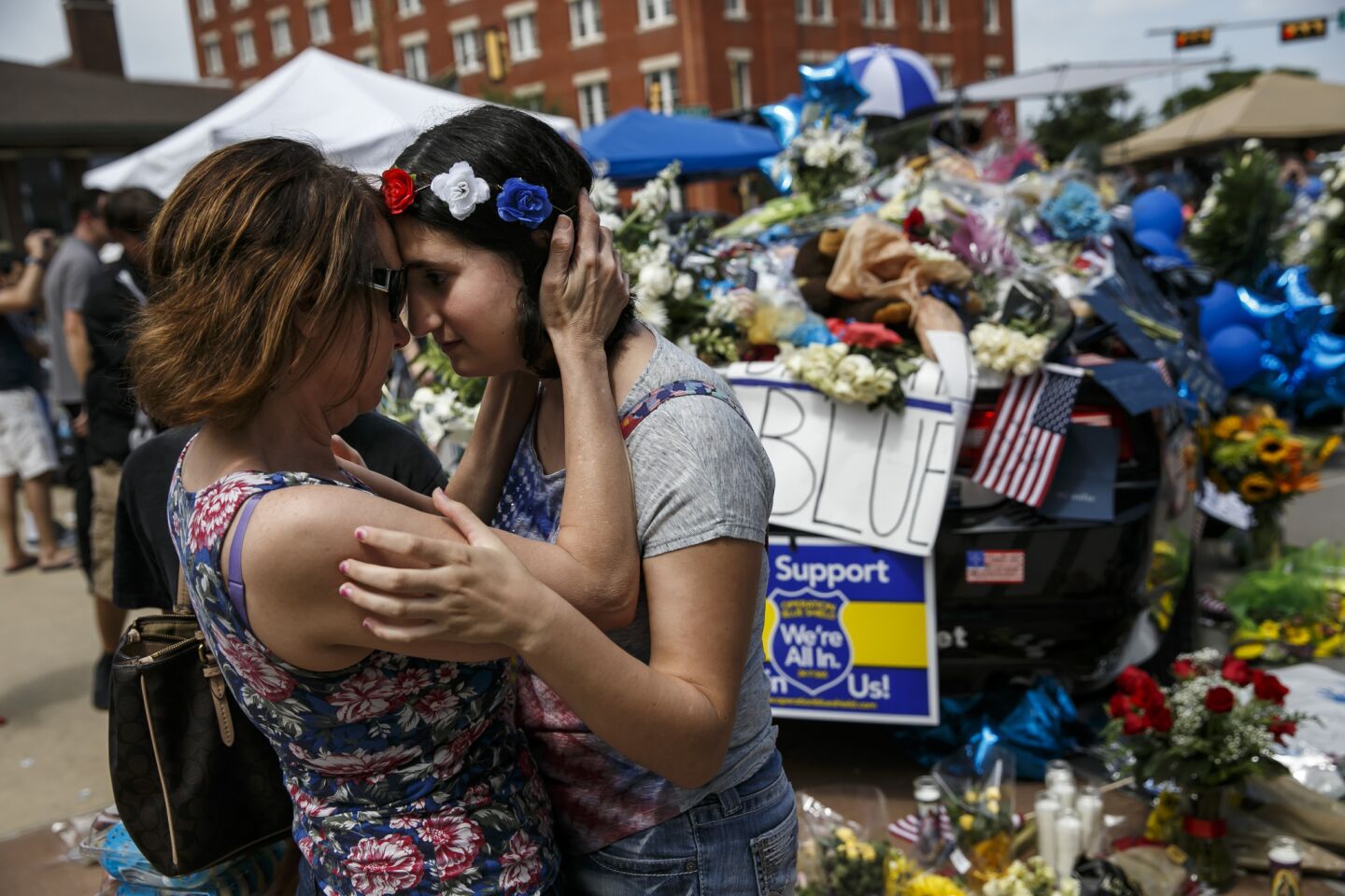 Rachel Simon embraces her daughter Abigail Simon, 13, as they pay their respects to the slain officers at a memorial outside Dallas Police Department.