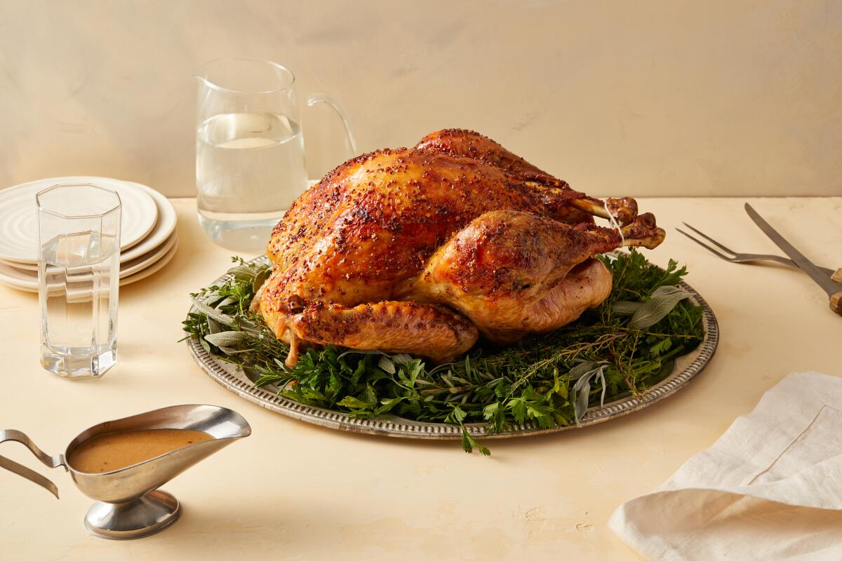 A maple glazed turkey plated on a tray of greens
