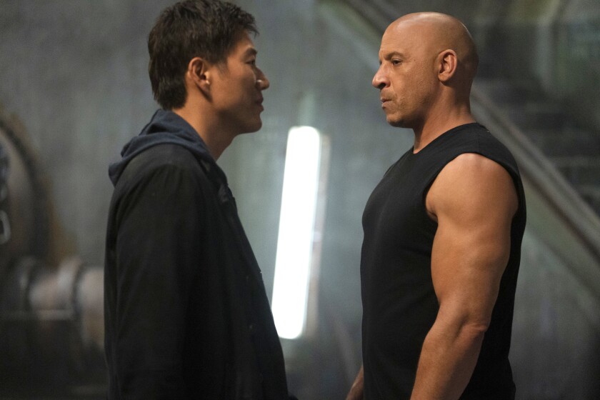 Sung Kang and Vin Diesel face each other in a scene from the movie "F9."