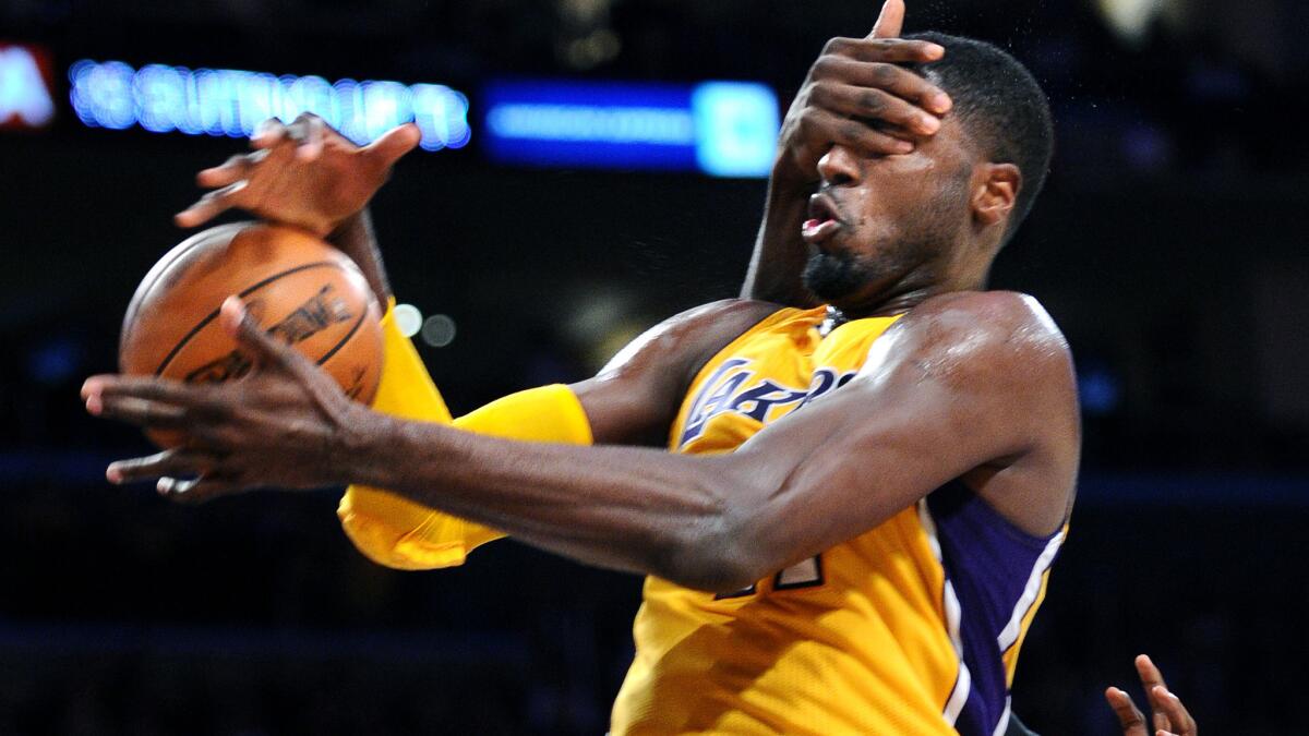 Lakers center Roy Hibbert gets hit in the face as he is fouled by Timberwolves center Gorgui Dieng in the third quarter.