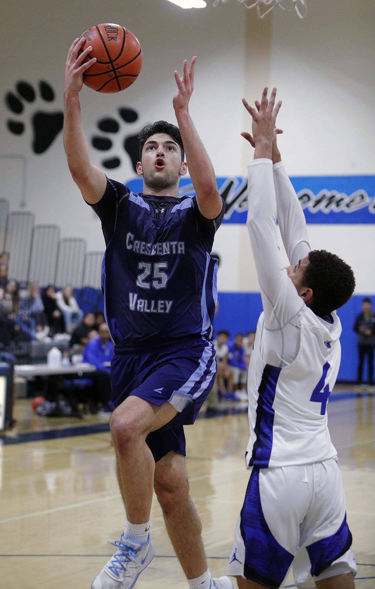 Crescenta Valley's Danny Khani drives against Burbank's Phoenix Mosley in a Pacific League boys' basketball game at Burbank High School on Thursday.