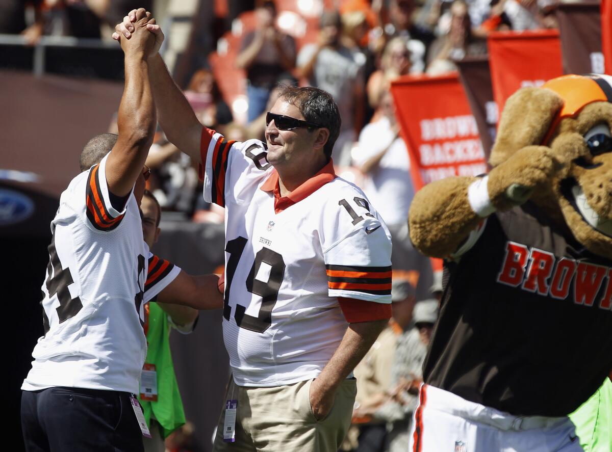 Former Cleveland Browns player Webster Slaughter and Bernie Kosar, right, are honored before the game against the Philadelphia Eagles on Sept. 9, 2012.