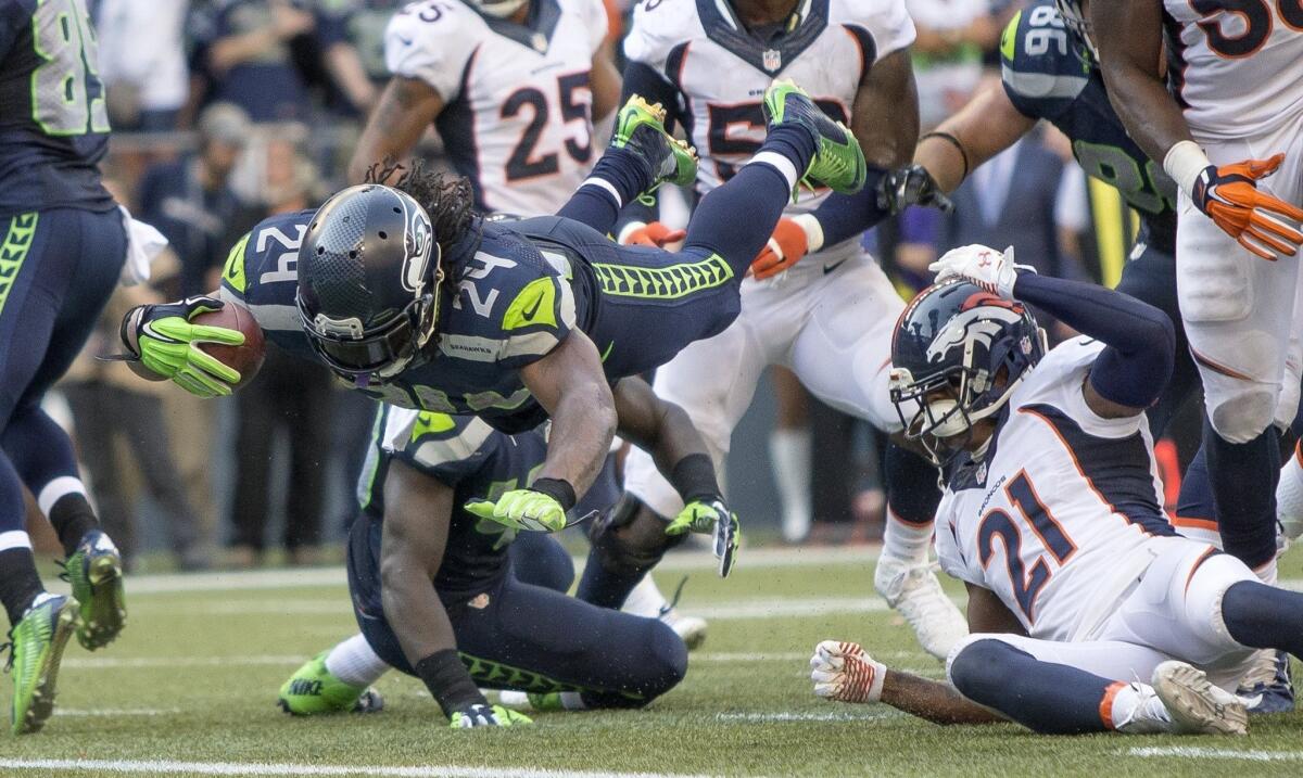 Seahawks running back Marshawn Lynch dives into the end zone to deliver Seattle's 26-20 win over the Broncos in overtime.