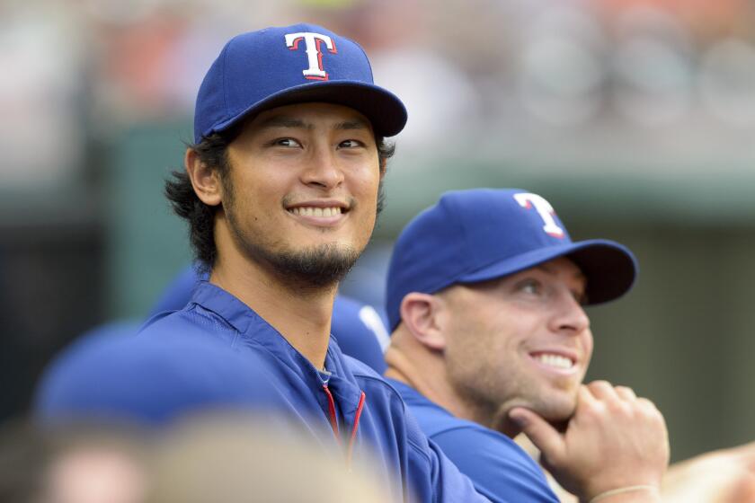 Texas' Yu Darvish watches a game against the Cleveland Indians from the dugout at Progressive Field on Aug. 1, 2014.