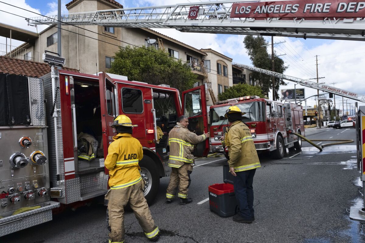 Los Angeles firefighters pack up after a fire at an apartment complex in the Sun Valley area of Los Angeles, Thursday, March 23, 2023. The fire in the Sun Valley area erupted at midday and flames were lapping up from a second-floor unit to the third floor when firefighters arrived, Fire Department spokesperson Margaret Stewart said in a statement. Several residents took refuge on top-floor balconies while firefighters attacked the flames. (AP Photo/Richard Vogel)