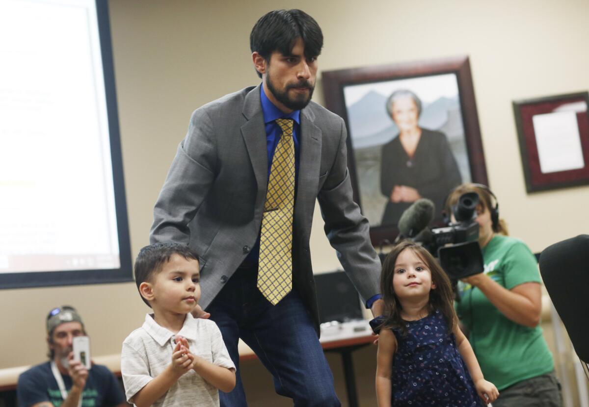 El fotógrafo de combate de la Fuerza Aérea de Estados Unidos Steve Otero (centro) lleva a sus hijos a ocupar su sitio antes de la audiencia en la que expresó su apoyo a la adición del Síndrome de Estrés Postraumático a la lista de males para los que se puede recetar marihuana como tratamiento el miércoles 15 de julio de 2015 ein Denver. (Foto AP/David Zalubowski)