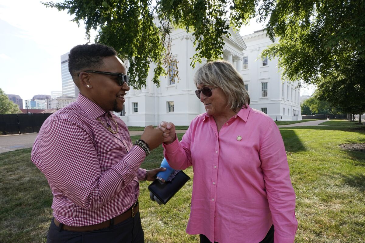 Nat McKeller Crosby, left, greets Lisa Turner in front of the State Capitol, Wednesday June 8, 2022, in Richmond, Va. The pair decided not to attend a reception at the Capitol given by Republican Virginia Gov. Glenn Youngkin for Pride Month. (AP Photo/Steve Helber)