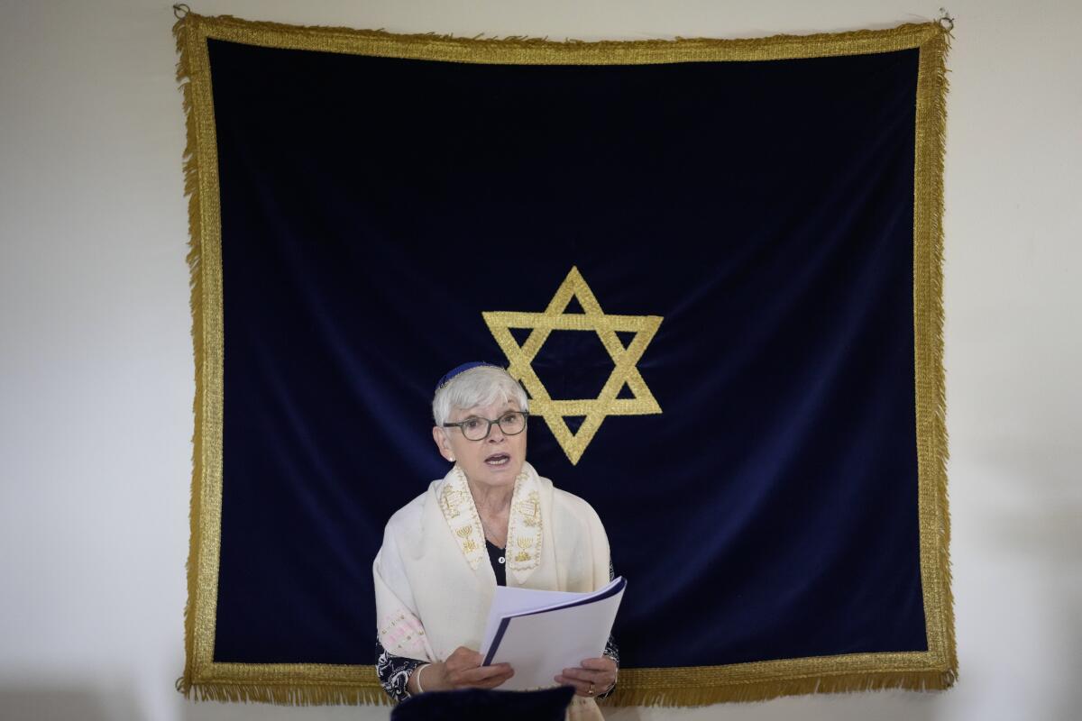 Rabbi Barbara Aiello reads prayers in her "Ner Tamid del Sud" (The Eternal Light of the South) synagogue in Serrastretta, southern Italy, Friday, July 8, 2022. From a rustic, tiny synagogue she fashioned from her family's ancestral home in this mountain village, American rabbi Aiello is keeping a promise made to her Italian-born father: to reconnect people in this southern region of Calabria to their Jewish roots, links nearly severed five centuries ago when the Inquisition forced Jews to convert to Christianity. (AP Photo/Andrew Medichini)