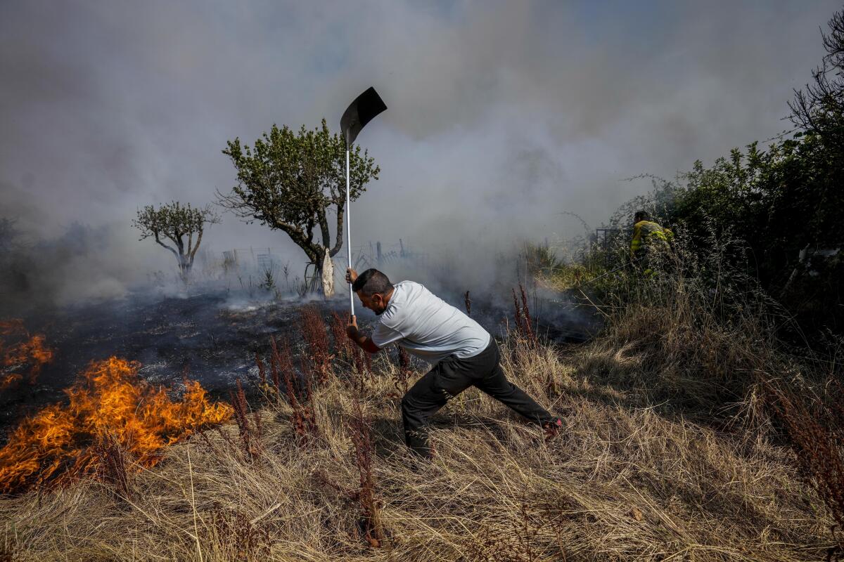 En esta imagen de archivo, un residente lucha contra el fuego con una pala, en Tabara, 