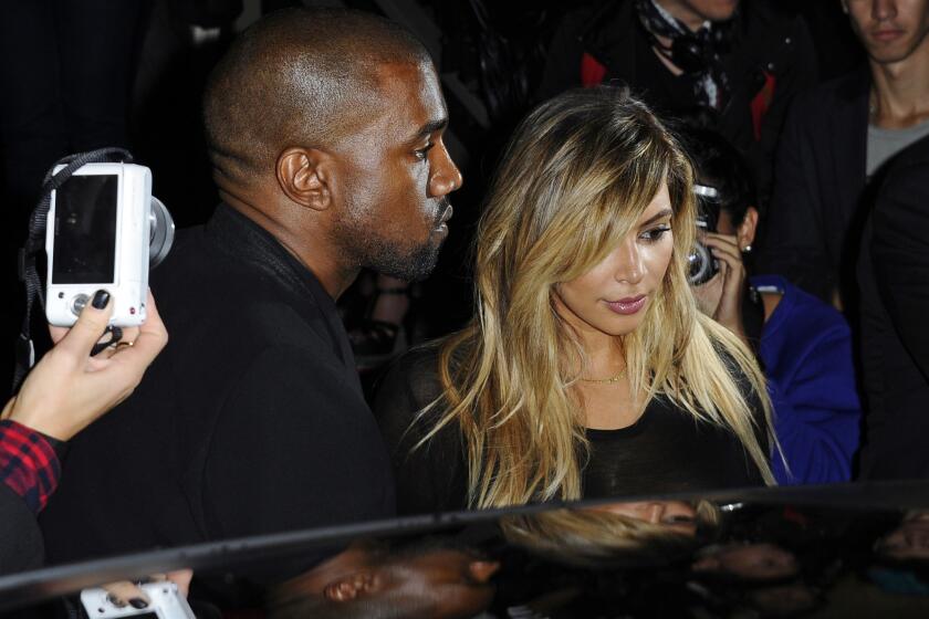 Kanye West and Kim Kardashian depart a showing of Givenchy's ready-to-wear spring/summer 2014 fashion collection in Paris.