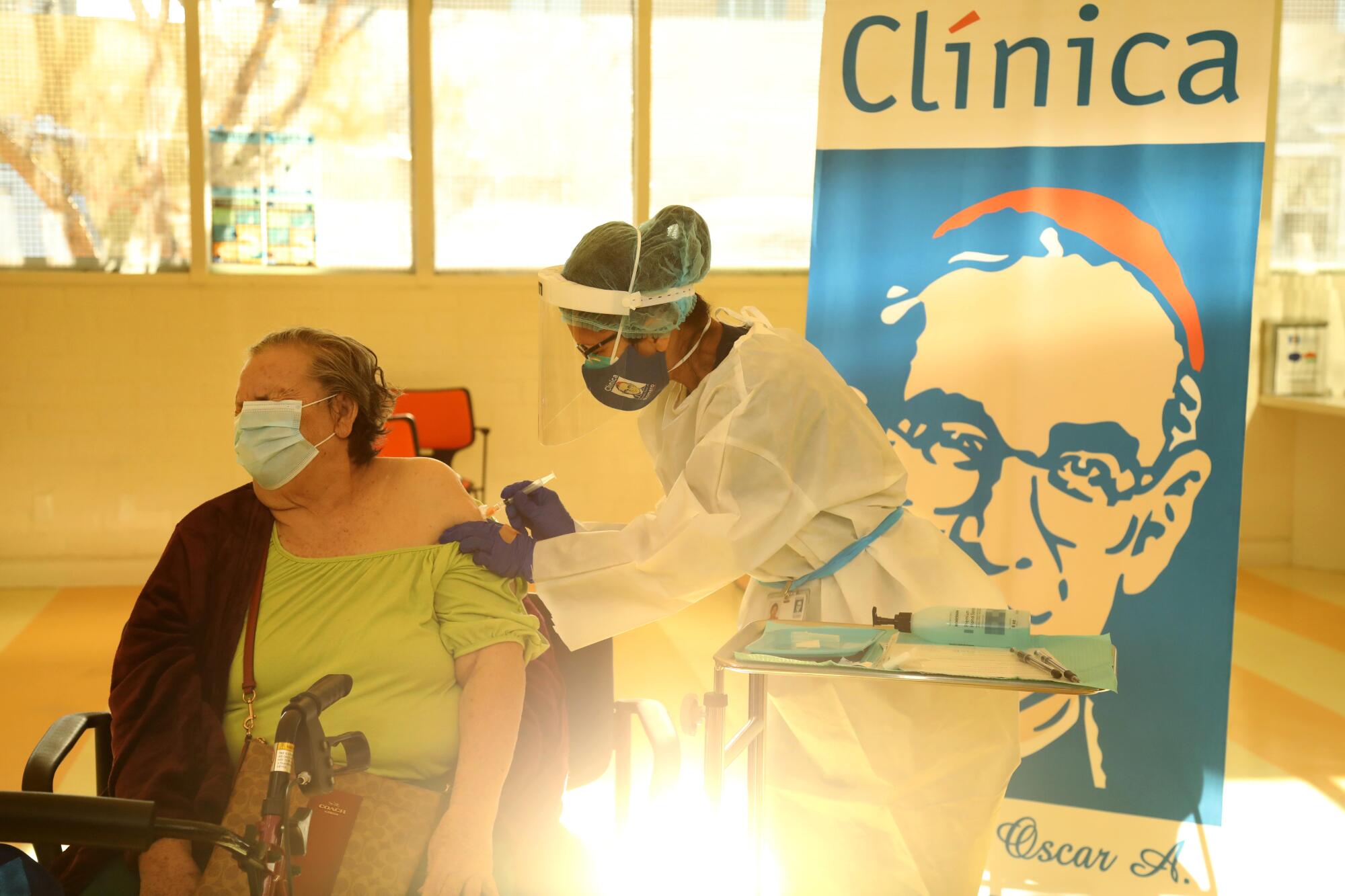  Ana Canales, 78, receives the Moderna COVID-19 vaccine from medical assistant Licelda Perez at Clínica Romero.