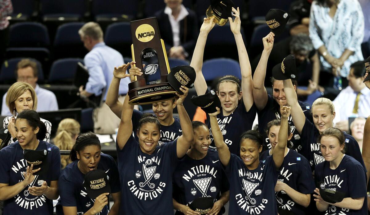 Connecticut players celebrate with the national championship trophy after defeating Notre Dame, 63-53, in the NCAA women's basketball national championship game on Tuesday in Tampa, Fla.