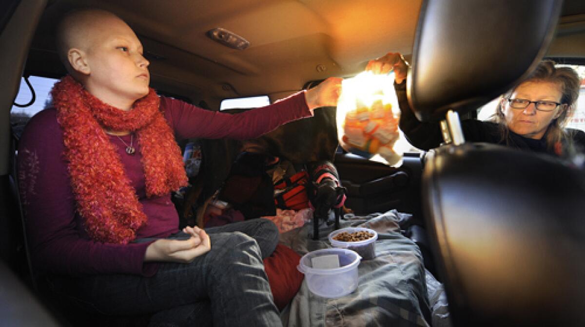 Kerry Himmel hands a bag of prescriptions to her daughter Destiny, 16, who suffers from high-risk acute leukemia. The two live in their SUV, moving occasionally from a McDonald's parking lot to a Ralphs parking lot to avoid eviction. More photos >>>