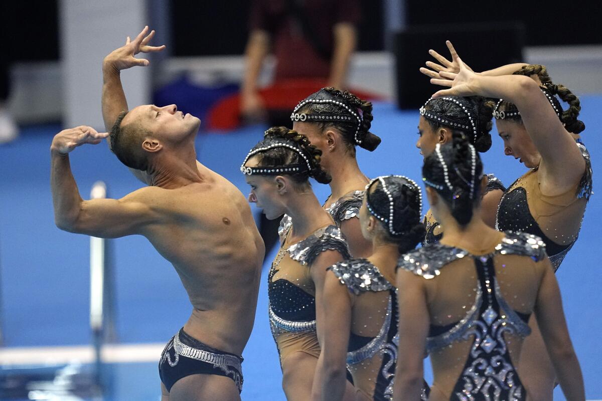 Bill May, left, leads the U.S. team out to compete in the team acrobatic artistic swimming competition