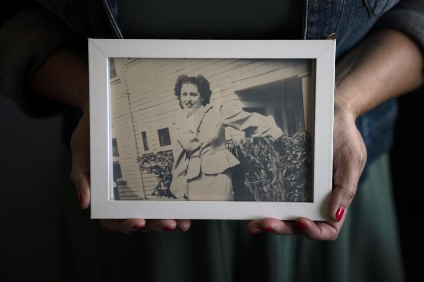 Stacy Cordova, whose aunt was a victim of California's forced sterilization program that began in 1909, holds a framed photo of her aunt Mary Franco, Monday, July 5, 2021, in Azusa, Calif. Franco was sterilized when she was 13 in 1934. Franco has since died, but Cordova has been advocating for reparations on her behalf. (AP Photo/Jae C. Hong)