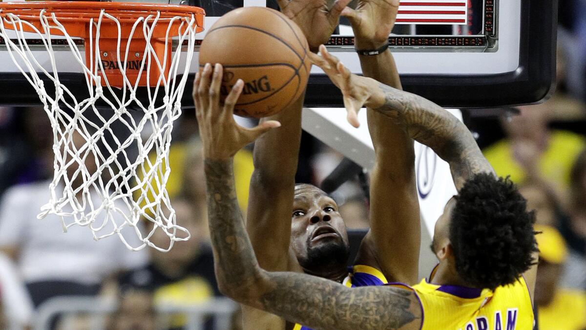 Lakers forward Brandon Ingram tries to score at the rim against Warriors forward Kevin Durant during a preseason game on Saturday night in Las Vegas.